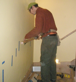 Scott Smith installing handrail on the stairway from the basement to the main floor
